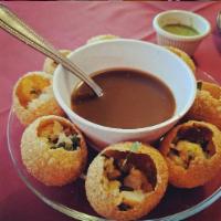 Pani Puri · 6 puffed flour bowls stuffed with potatoes, chickpeas, tangy spices and tamarind water.