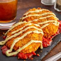 Giant Fried Ravioli · Two jumbo raviolis filled with creamy ricotta, hand-breaded and deep fried. Served on a bed ...