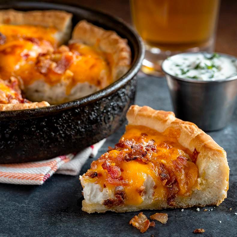 Pizza Skins · UNO's signature deep dish pizza crust stuffed with mashed red bliss potatoes and topped with bacon and cheddar. Sour cream on the side.