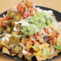 Nachos Supremos · Tortilla chips smothered with melted cheese, black beans, lettuce, and tomato. Topped with g...