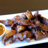Beef Jerky · Deep fried marinated dry-beef served with Thai sweet chili sauce.