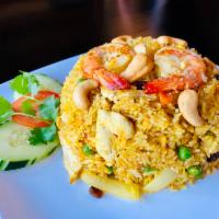 Pineapple Fried Rice · Stir-fried rice with chicken and shrimp, egg, pineapple, onion, raisin, pea and carrot and c...
