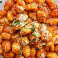 Gnocchi Sorrentina · Homemade potato dumplings in a light plum tomato sauce topped with fresh mozzarella and basil.