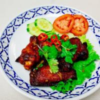 Spicy Chicken Wings · Deep fried marinated tom yum flavor wings with Thai herbs garnished. Spicy