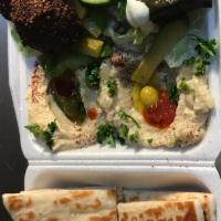 22. Mazzat Veggie Plate · Combination of hummus, baba ghanoush, dolma, falafel pieces, 1 pita, tzatziki and tahini.
