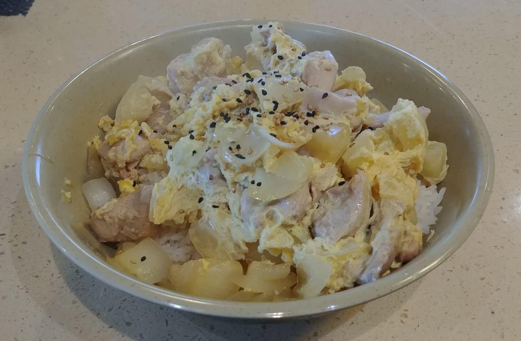 Oyako Don · Simmered chicken scrambled with eggs and onions with sesame seeds over steamed rice. Served with miso soup and salad.
