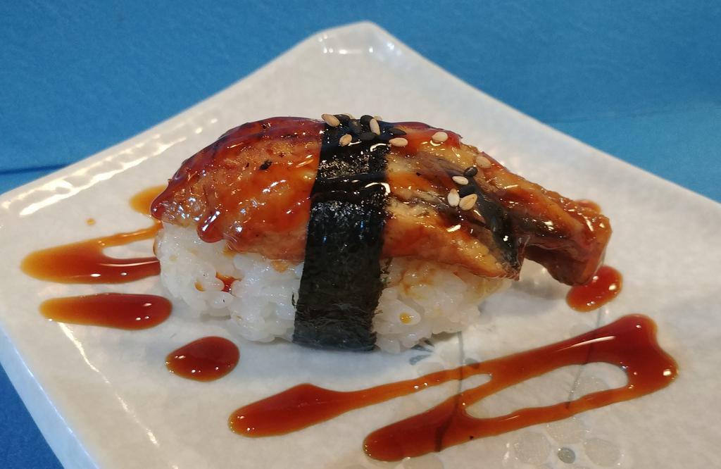 Unagi Nigiri · Broiled eel, sushi rice, sesame seeds, seaweed, unagi sauce.