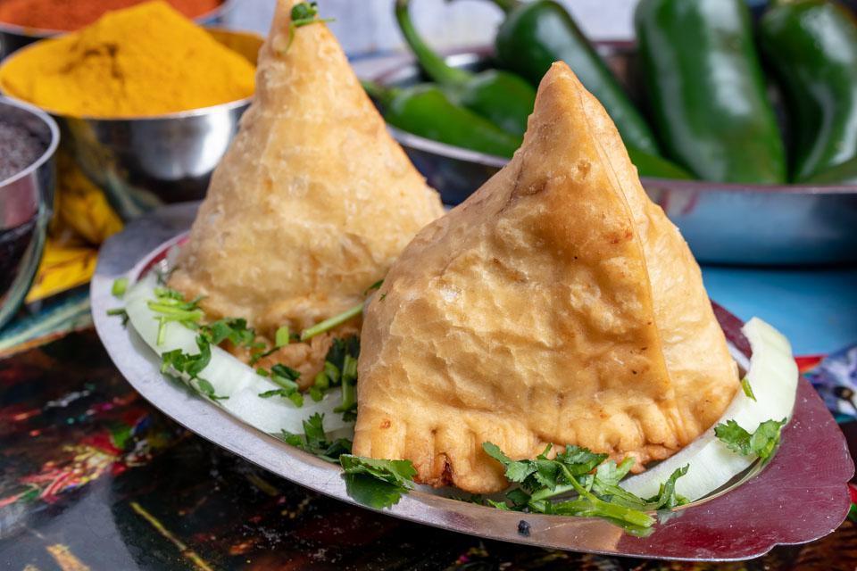 2 Pieces Vegetable Samosa · 2 deep fried triangular shape pastry stuffed with mildly spiced potatoes, green peas and garden herbs.