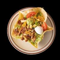 Taco Salad · A crispy flour tortilla shell topped with beans your choice of meat, lettuce, sour cream, gu...