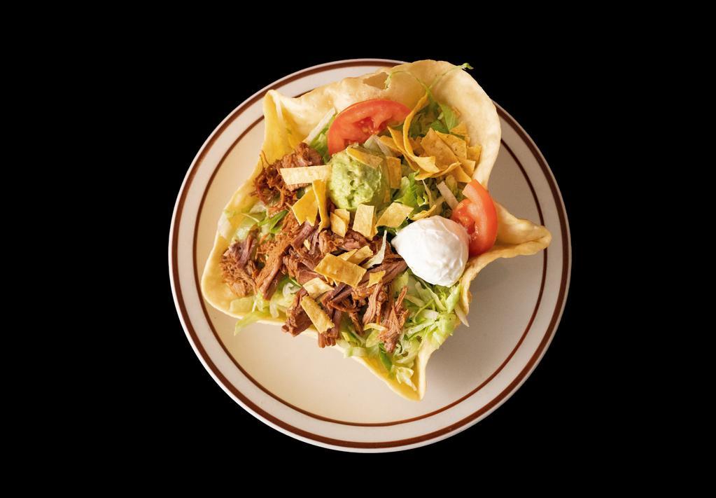Taco Salad · A crispy flour tortilla shell topped with beans your choice of meat, lettuce, sour cream, guacamole, Cheddar cheese, tomatoes, and crispy corn, and tortilla chips.