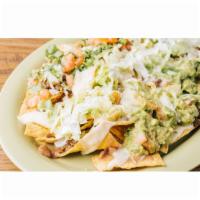 Nachos · Chips topped with beans, cheese, your choice of meat, lettuce, tomatoes, green onions, guaca...