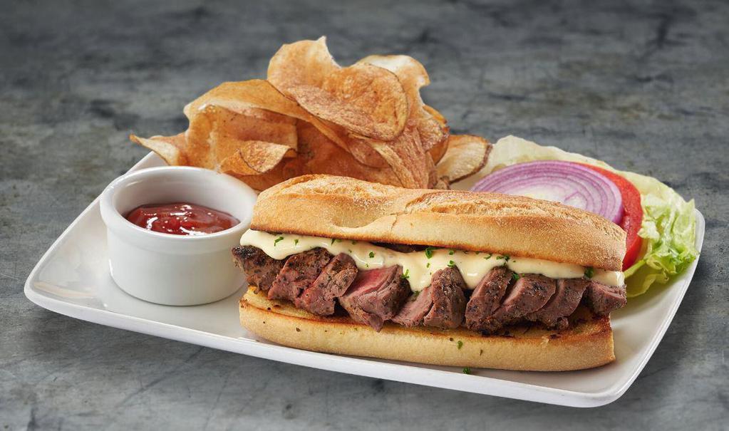 Steak Sandwich* · Sliced filet on garlic bread, prepared with béarnaise sauce, served with lettuce, tomato & onion and hand-cut potato chips.