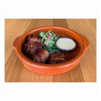 Chorizo Stuffed Dates · Medjool dates, homemade chorizo, wrapped in bacon. Served with an arugula salad