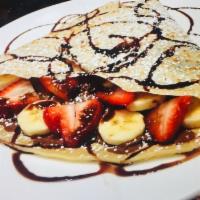 Crepe Royale · Fresh bananas and strawberries, Nutella and chocolate sauce. Served with whipped cream and p...