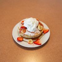 Strawberry Banana Pancakes Breakfast · 4 pancakes topped with fresh strawberry and banana dusted with powder sugar topped with whip...