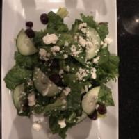 Greek Salad · Crispy romaine heart, tomatoes, cucumbers, onions, olives and feta cheese tossed with Greek ...