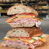 #21. Colombo Sandwich · Cracked pepper turkey, cheddar, cucumbers, tomato with herb mayo on 7-grain sliced bread.