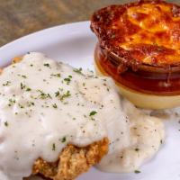 Lunch Country Fried Steak Plate · Country fried steak topped with pepper gravy and served with a side of baked mac and cheese.