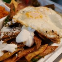 Chilaquiles con Huevo · Crispy tortilla chips sauteed with red or green sauce, topped with sour cream and cotija che...