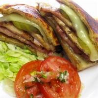 Cuban Sandwich · Tradicional Cuban sandwich: ham, pork shoulder, melted Swiss cheese, pickles and mustard.