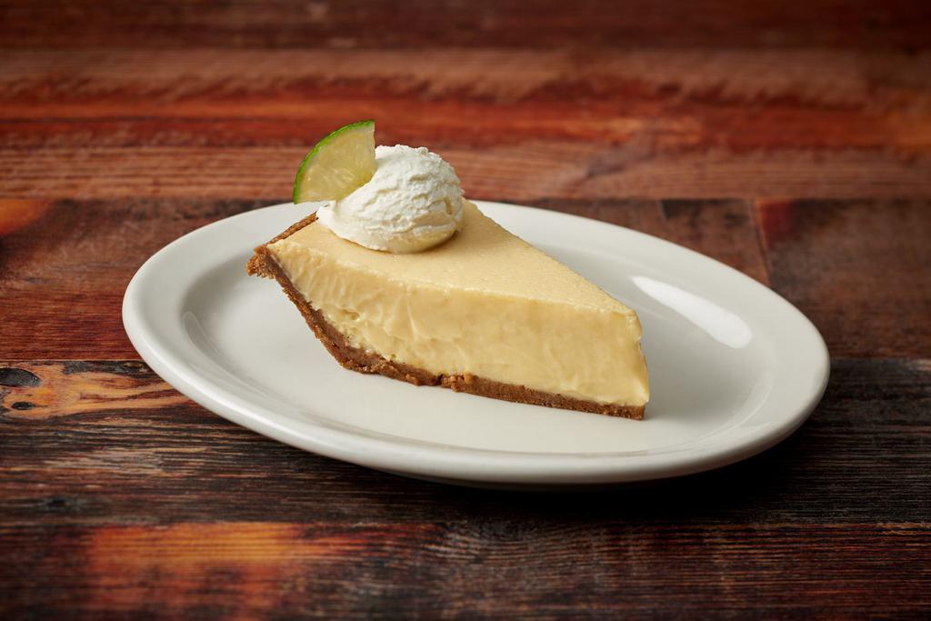 Slice Keylime Pie · Graham Cracker Crust Filled with Fresh Key Lime & Baked Topped with Fresh Whipped Cream