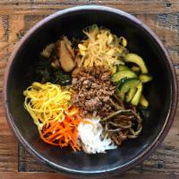 Bi Bim Bap (비빔밥) · Rice topped with ground beef, raw egg york and sauteed and seasoned vegetables. Contains ses...