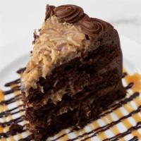 German Chocolate Cake, slice · Moist chocolate cake with our homemade caramel-coconut-pecan filling. Iced with chocolate bu...