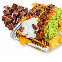 Carne Asada Nachos · Corn tortilla chips loaded with melted cheese and choice of toppings