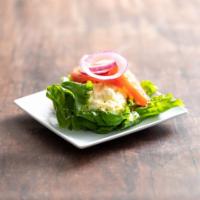 Egg Cup Salad · A bed of lettuce with tomato and onion.