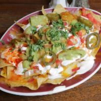 Regular Nachos · Crispy tortilla chips covered with melted cheese and either black or pinto beans. Served wit...