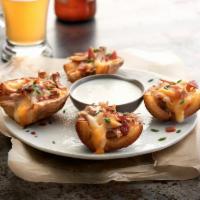 Loaded Skins · Roasted potatoes topped with Jack and cheddar cheese and bacon. Served with chive dip.
