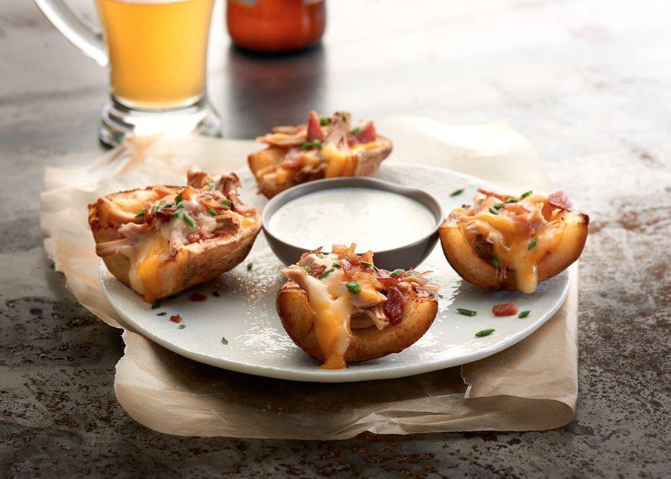 Loaded Skins · Roasted potatoes topped with Jack and cheddar cheese and bacon. Served with chive dip.
