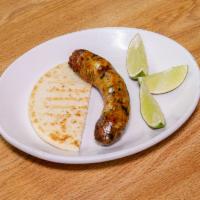 Chorizo con Arepa · Homemade Colombia sausage with traditional corn patty.