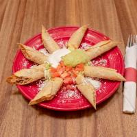 Taquitos de Pollo · Served with lettuce, crema, guacamole, tomatoes and Parmesan cheese.