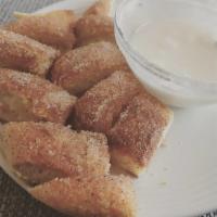 Famous Cinnamon Sticks · Warm dough tossed in our signature cinnamon butter & served with a delicious cream cheese fr...