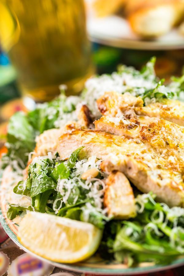 Caesar Salad · Romaine hearts tossed with Parmigiano-Reggiano, croutons, and Caesar dressing. Pictured has chicken added.
