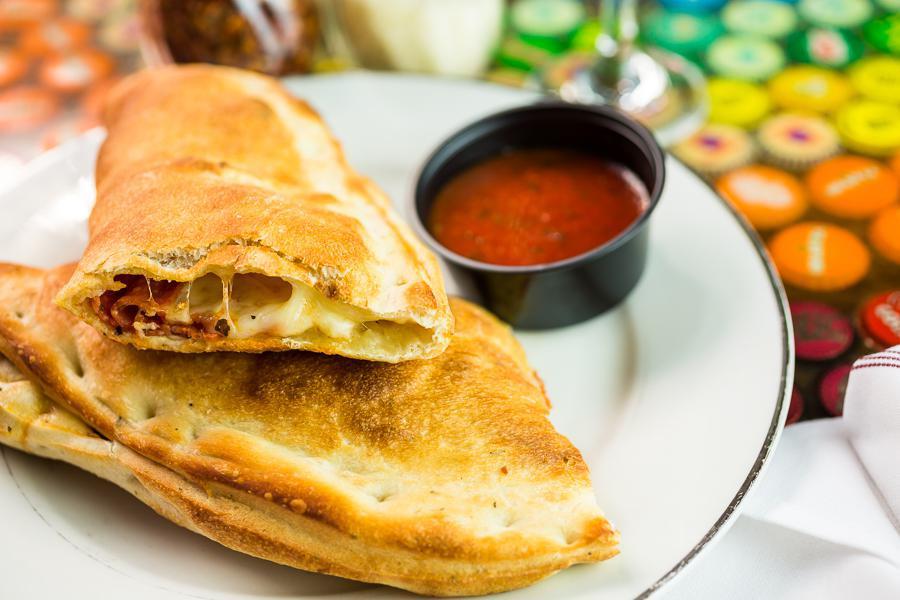 Create Your Own Calzone · Pasquini family recipe pizza sauce, Mozzarella and your choice of pizza toppings. Served with a side of pizza sauce.
