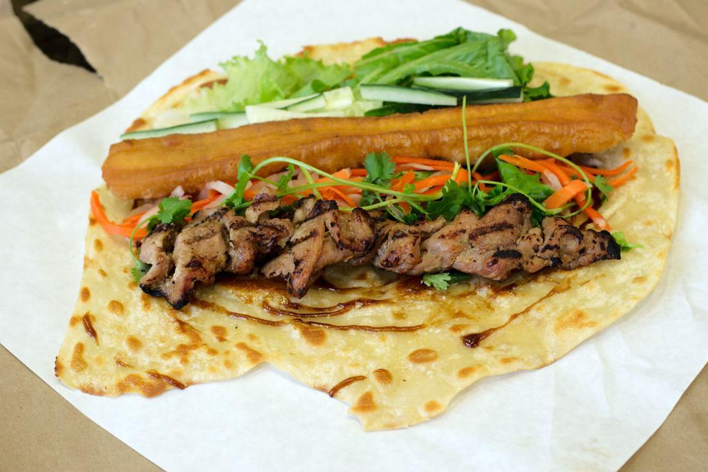 Grilled Pork Zhua Bing Roll · grilled pork, green leaf, cilantro, cucumber, pickled daikon and carrot in a pancake wrap