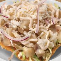 Pata de Res Tostada · Beef feet. Served with cabbage, sour cream, and cheese.