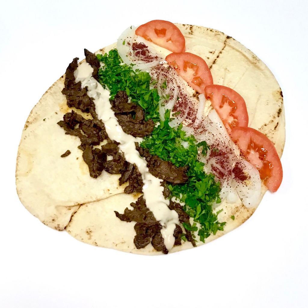 Beef Shawarama Wrap · Served with tomatoes, parsley, onions, sumac and tahini sauce.