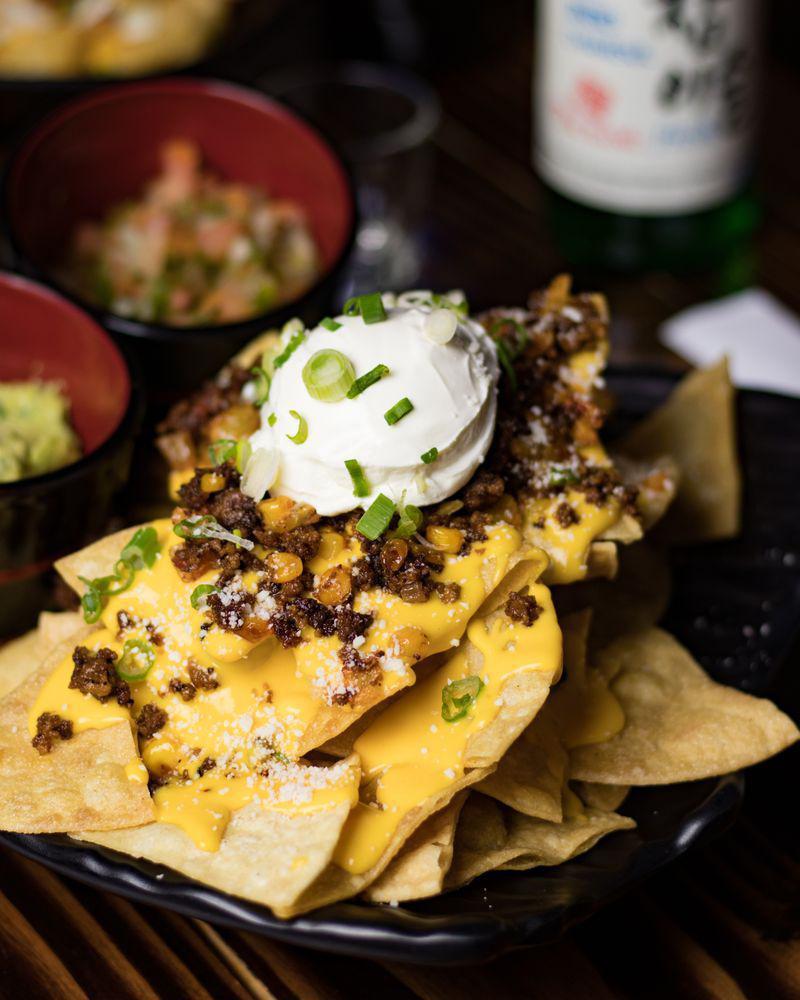 Toe Bang Nachos · Crispy nacho chips topped with beef, salsa, sour cream, green onions, and nacho cheese.