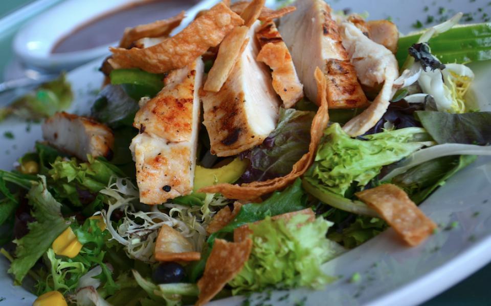 Southwest Salad · Sweet corn, black beans, bell peppers, avocado, red onions, mixed greens tossed in a roasted red pepper vinaigrette and topped with tortilla chips. Add grilled or rotisserie chicken for an additional charge.