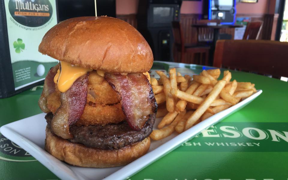 Milwaukee Burger · Topped with onion rings, white cheddar cheese curds, hickory-smoked bacon, and cheddar cheese sauce.