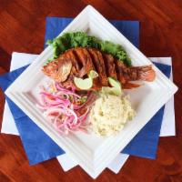 Whole Fried Tilapia · Served with sliced onions and rice.