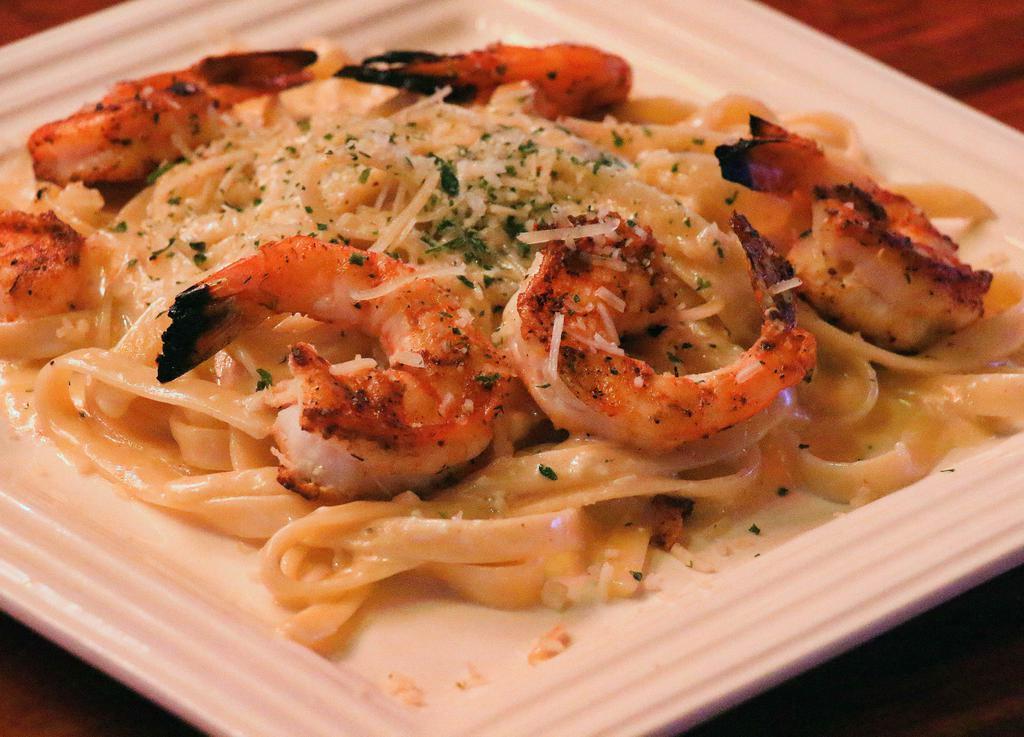 Shrimp Parmesan Pasta · Blackened shrimp tossed in fettuccine alfredo with parmesan cheese sprinkled on top and served with two pieces of garlic bread.