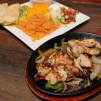 Fajitas · Chicken or beef fajitas served with Spanish rice
and charro beans. Comes with sour cream,
gu...