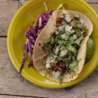 Carnitas Taco · Tender slow roasted shredded pork topped with cilantro and onions.