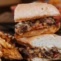 Philly Cheese steak · Shaved sirloin, american + pepper jack cheese, grilled onions and peppers. Served with waffl...
