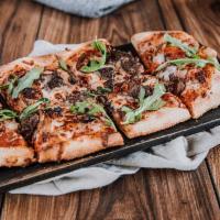 Grilled Wagyu  · Wagyu beef, oven-roasted tomato, mozzarella, caramelized onion, spicy red sauce, arugula.