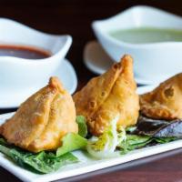 Vegetable Samosa · Crispy fried turnovers deliciously filled with mildly spiced potatoes and green peas.